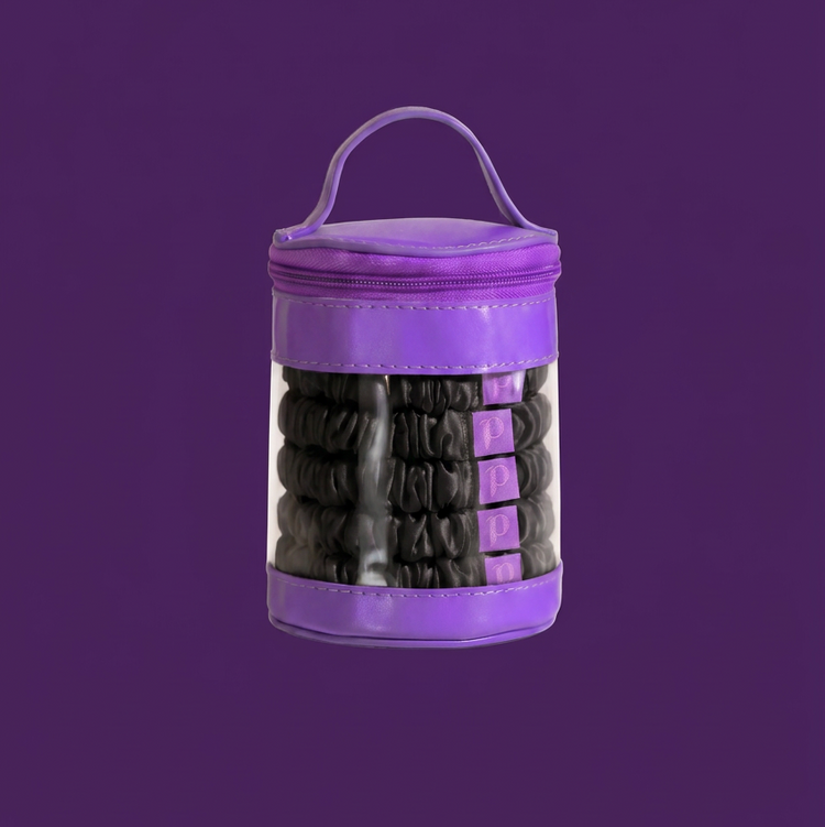 A purple cylindrical zippered storage bag with a clear front panel showing black hair ties inside, set against a solid purple background.